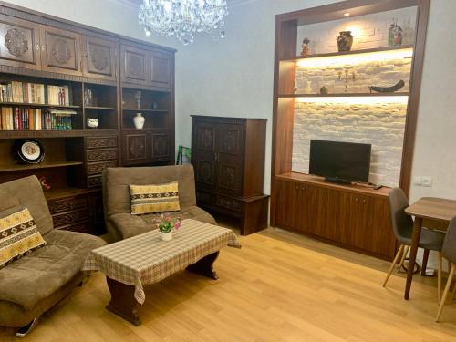 ein Wohnzimmer mit einem Sofa und einem TV in der Unterkunft Best Location Renovated Home in Tbilisi City