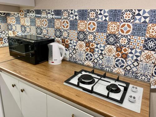 ein Kochfeld in einer Küche mit einer Mikrowelle in der Unterkunft Best Location Renovated Home in Tbilisi City