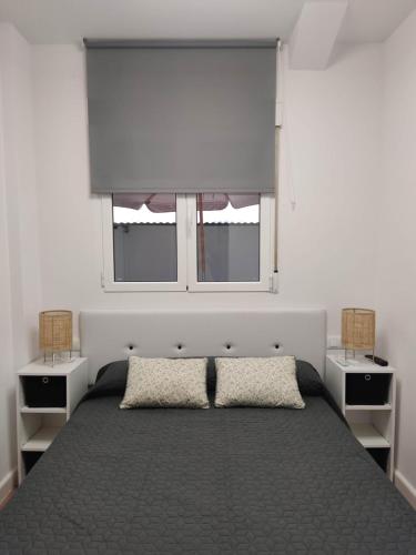 a bedroom with a large bed with two windows at benimaclet delux3 in Valencia