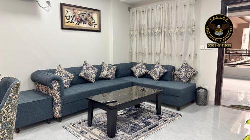 a living room with a blue couch and a table at Two Bed Luxury Apartment in Islamabad