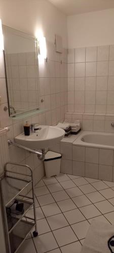 een witte badkamer met een wastafel en een bad bij Ferienwohnung Altstadt-Domizil Hameln in Hameln