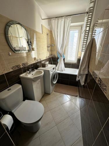 ein Badezimmer mit einem WC, einem Waschbecken und einer Badewanne in der Unterkunft Noclegi Murzynowskiego in Olsztyn