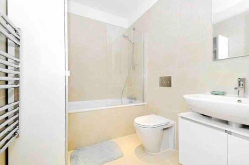 La salle de bains blanche est pourvue d'un lavabo et de toilettes. dans l'établissement Modern 2 Bed, 2 Bath Flat in Central London Zone 1, à Londres