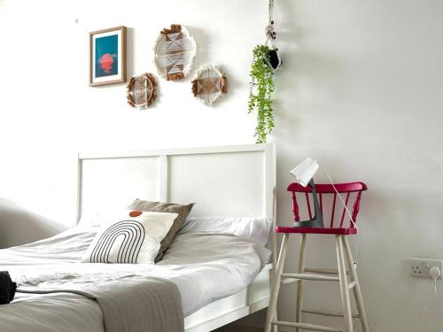 - une chambre avec un lit blanc et un tabouret rouge dans l'établissement Modern 2 Bed, 2 Bath Flat in Central London Zone 1, à Londres