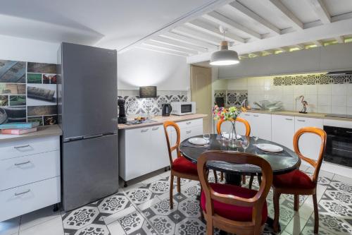 une cuisine avec une table, des chaises et un réfrigérateur dans l'établissement Le Théâtre - Appartement Spacieux, Centre ville & Calme, à Montpellier