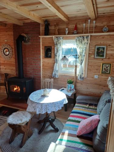 a living room with a table and a stove at Magia Krutyni Domek nr2 in Ukta