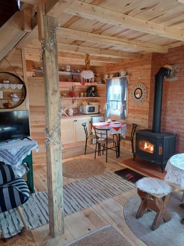 a kitchen and dining room with a stove in a log cabin at Magia Krutyni Domek nr2 in Ukta
