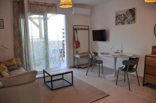 a living room with a couch and a table at Studio en bord de mer sur Costa Serena N54 in Linguizzetta