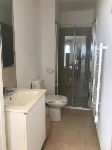 une salle de bain blanche avec toilettes et douche dans l'établissement Studio en bord de mer sur Costa Serena N54, à Linguizzetta