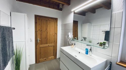 La salle de bains est pourvue d'un lavabo et d'un miroir. dans l'établissement Haus-no19 GbR, à Kippenheim