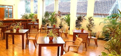 un restaurante con mesas, sillas y macetas en Dream Palace Family Guest House Mirissa, en Mirissa