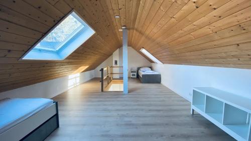 a room with a wooden ceiling with a skylight at Haus-no19 GbR in Kippenheim