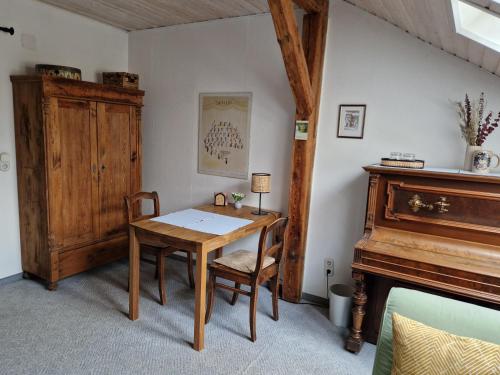 ein Esszimmer mit einem Tisch und einem Klavier in der Unterkunft Gästezimmer John in Weimar