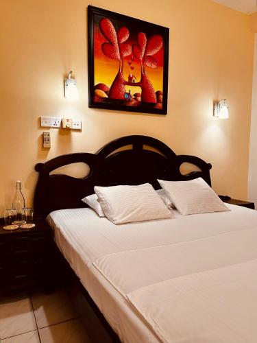 a bedroom with a large bed with white sheets at Luna Waves in Negombo