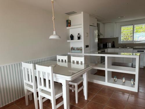 una cocina con mesa blanca y sillas. en Villa Alex Altafulla Hermosa casa con espectaculares vistas al mar y a tocar de una idílica calita, en Altafulla