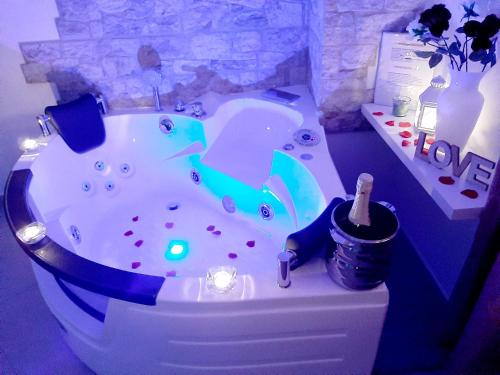 a bathroom with a tub with a bottle of champagne at LA MURGIA casa vacanze B&B in Grumo Appula