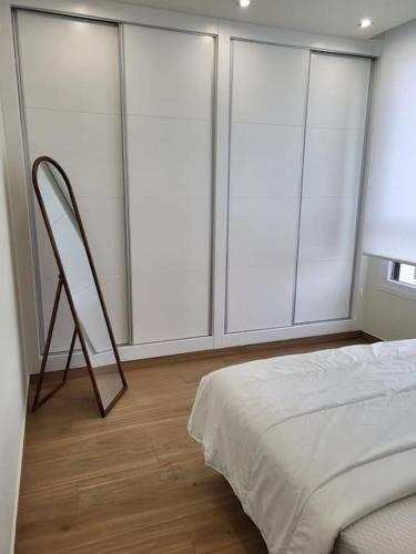 a bedroom with large windows with a bed and a chair at Casa Eden luxury villa in Rojales in Rojales