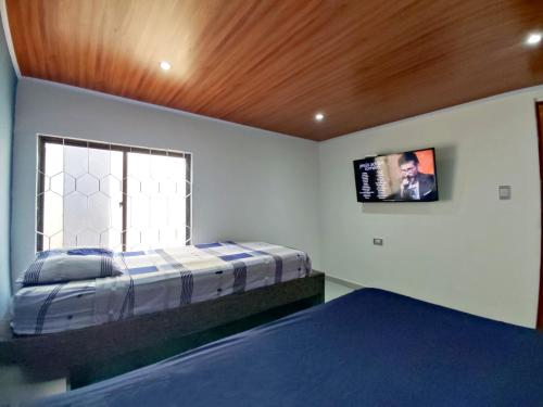 a bedroom with a bed and a tv on the wall at Acogedor Apartamento Alpha in Cartagena de Indias