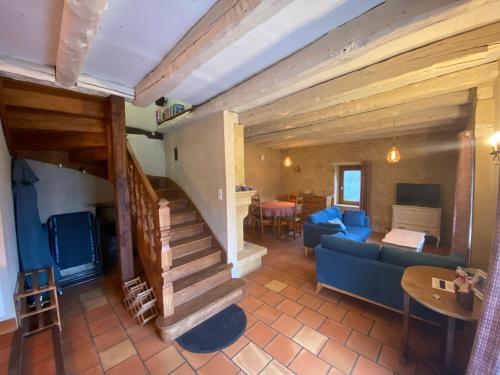 a living room with a blue couch and a staircase at Gite Introvigne Sarlat in Sarlat-la-Canéda