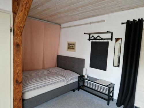 a small bedroom with a bed and a table at Gästezimmer John in Weimar