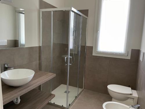a bathroom with a shower and a toilet and a sink at Polinesia 12 in Lido delle Nazioni