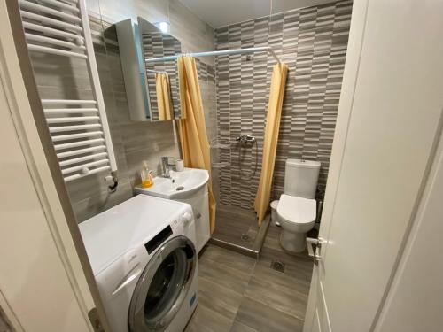 a bathroom with a washing machine and a toilet at Danka Apartment in Thessaloniki