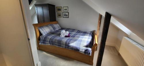 a small bedroom with a bed with a blue plaid blanket at Stunning 1-Bed Studio in Windsor in Windsor