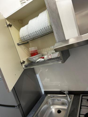 a kitchen with a sink and a shelf with towels at Roby & Simo in San Giorgio a Cremano