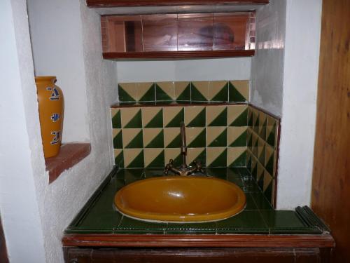 La salle de bains est pourvue d'un lavabo brun et d'un comptoir vert. dans l'établissement a l'ombre des micocouliers, à Sorède