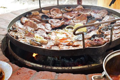 a large pan of food cooking on a grill at Tündérfátyol apartmanház in Poroszló