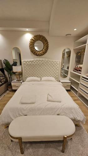 een slaapkamer met een groot bed en een spiegel bij UG Neubau City Wohnung (Pool+Gym extra buchbar für €150/Tag) in München