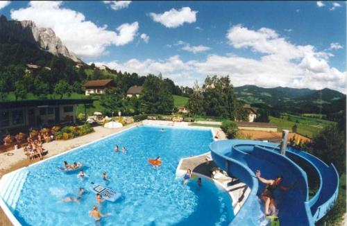 a large swimming pool with people in the water at Ferienhaus Walcher in Sankt Martin am Grimming