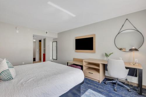 a bedroom with a bed and a desk and a mirror at The Kingston in Savannah