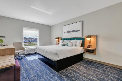 um quarto de hotel com uma cama, uma secretária e uma janela em The Kingston em Savannah