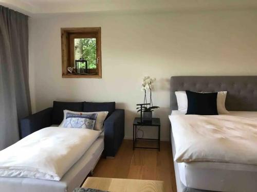 ein Schlafzimmer mit zwei Betten und einer Couch und einem Spiegel in der Unterkunft Haus Hochland - Moderne Alpenwohnung Garten&Natur in Bad Kohlgrub