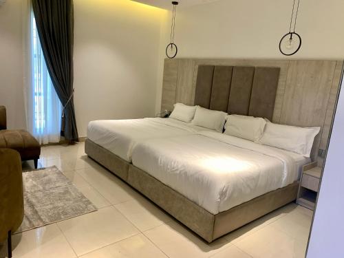 1 dormitorio con 1 cama grande con sábanas blancas en Polo grand hotel, en Maiduguri