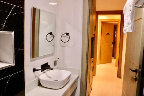 ein Badezimmer mit einem weißen Waschbecken und einem Spiegel in der Unterkunft Polo grand hotel in Maiduguri