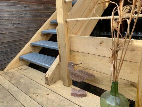 une statue d'oiseau en bois dans un vase à côté des escaliers dans l'établissement Au nid'Elma, à Breitenau