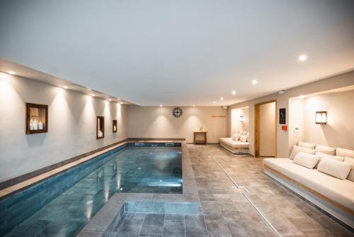 una gran piscina en una habitación con sofá y sofá en Hôtel de la Roche en Beaufort