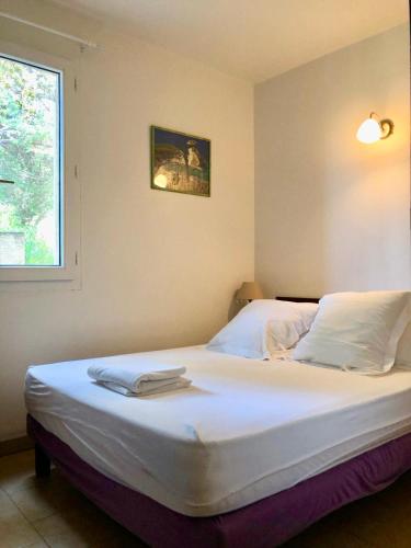 a bedroom with a large white bed with a window at Résidence Padovani Marina in Calcatoggio