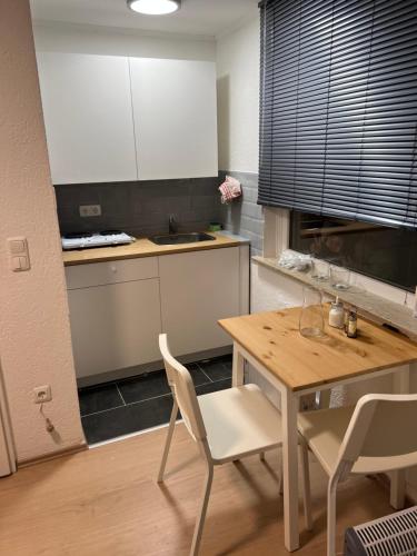 a kitchen with a table and chairs and a sink at Main Appartement in Flörsheim