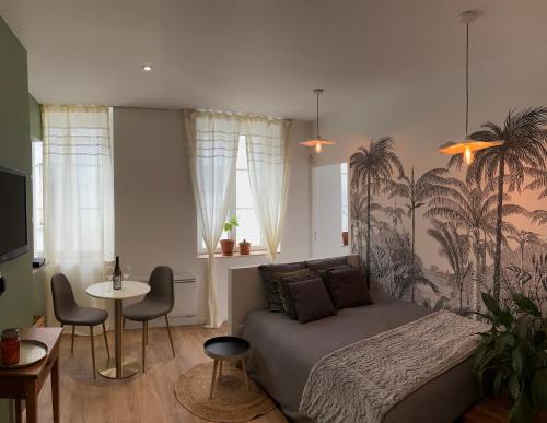 une chambre avec un lit, une table et des chaises dans l'établissement Le Baraban : Cocon hypercentre, à Saint-Étienne