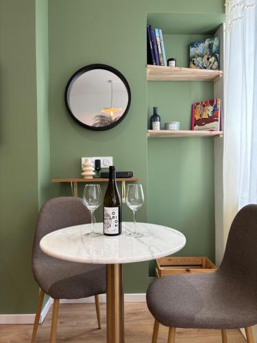 - une table avec 2 verres à vin et un miroir dans l'établissement Le Baraban : Cocon hypercentre, à Saint-Étienne