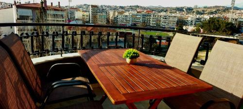 a wooden table with a potted plant on a balcony at Sky view suite serres in Serres