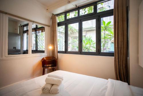 ein Schlafzimmer mit einem Bett und zwei Fenstern in der Unterkunft Loft branché dans le quartier le plus tendance de Paris in Paris