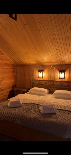 a bedroom with a bed with two towels on it at Rich OAK - готель з відкритим панорамний басейном in Yablunytsya