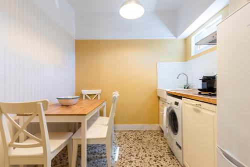 a kitchen with a table and a washing machine at Urban Senses Apt #2, a KalamataStay Property in Kalamata