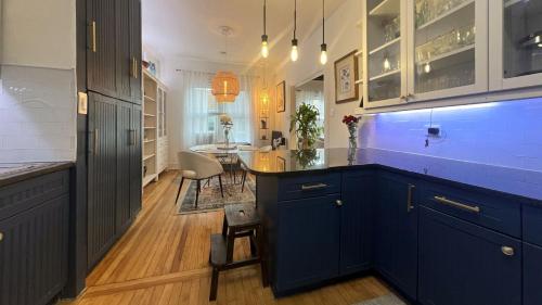 een keuken met blauwe kasten en een eetkamer bij Lakeside Loft - Historic Chicago Condo in Chicago