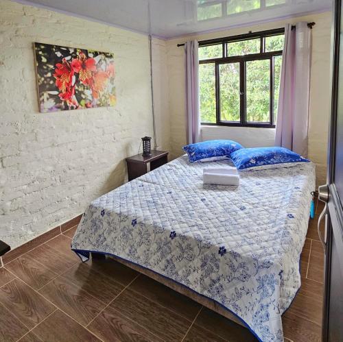 um quarto com uma cama com almofadas azuis e uma janela em Villa Susana em Filandia