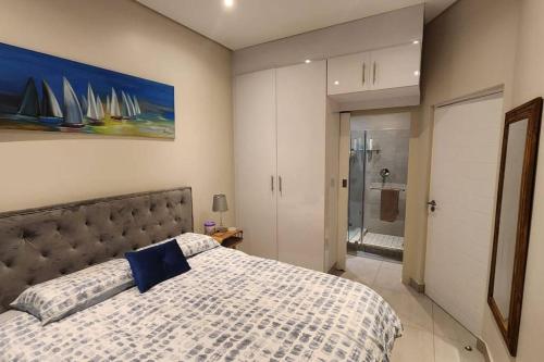 ein Schlafzimmer mit einem Bett und einem Wandgemälde in der Unterkunft Low Tide in Densainagar